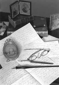 Black and white photo of old-fashioned letters and pens on desk